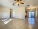 Spacious living room with tile flooring, a ceiling fan, and access to the kitchen, ideal for entertaining at 430 Short Dr, Kissimmee, FL 34759