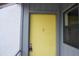 Close-up of a cheerful yellow front door with a classic knocker and secure lock at 4378 Aqua Vista Dr # L, Orlando, FL 32839