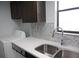 Kitchen featuring stainless steel sink, mosaic tile backsplash, and washer-dryer hookups at 4378 Aqua Vista Dr # L, Orlando, FL 32839