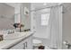 Bright bathroom features a white vanity, shower, and tub with a decorative shower curtain at 4501 Hummingbird Ln, Haines City, FL 33844