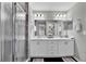 Bathroom with double sink vanity, framed mirror, ample lighting, and a glass-enclosed shower at 4501 Hummingbird Ln, Haines City, FL 33844