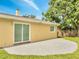 Backyard features a sliding glass door, a concrete patio, a well-maintained lawn, and mature trees at 4521 Alrix Dr, Orlando, FL 32839