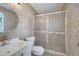 Bathroom offers a glass-enclosed shower, sink, vanity, round mirror, and beige-tiled walls at 4521 Alrix Dr, Orlando, FL 32839
