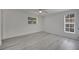 Bedroom features wood-look flooring, two windows offering plenty of natural light, and a ceiling fan at 4521 Alrix Dr, Orlando, FL 32839