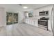 Well-lit kitchen features updated appliances, white cabinets, light counters, and sliding door access to outside at 4521 Alrix Dr, Orlando, FL 32839