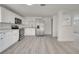 Bright kitchen featuring white cabinets, stainless steel appliances, and light gray wood-look flooring at 4521 Alrix Dr, Orlando, FL 32839