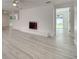 Bright living room featuring a painted brick fireplace, neutral walls, and sleek, modern flooring at 4521 Alrix Dr, Orlando, FL 32839