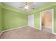 Bright bedroom with a ceiling fan, carpeted floor, and an ensuite bathroom at 4551 Hunting Lodge Dr, St Cloud, FL 34772