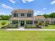 Inviting two-story home featuring a cozy front porch and meticulously landscaped garden at 4551 Hunting Lodge Dr, St Cloud, FL 34772