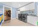 Cozy laundry room with new washer and dryer, ample cabinet space, and blue accent walls at 4551 Hunting Lodge Dr, St Cloud, FL 34772