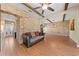 Living room showcasing a stone accent wall, beamed ceiling, and hardwood floors creating a cozy atmosphere at 4551 Hunting Lodge Dr, St Cloud, FL 34772