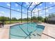 A sparkling pool is surrounded by lush greenery in a spacious screened-in enclosure with brick patio at 4551 Hunting Lodge Dr, St Cloud, FL 34772