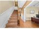Carpeted staircase with wood railing, paneled wall and landing with views to the downstairs at 4551 Hunting Lodge Dr, St Cloud, FL 34772