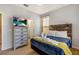Well-lit bedroom featuring a bed with a wooden headboard, swan towel art and a dresser with a TV at 477 Orange Cosmos Blvd, Davenport, FL 33837