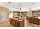 Kitchen with wood cabinets and stainless-steel dishwasher with an open view to the dining and living area at 477 Orange Cosmos Blvd, Davenport, FL 33837