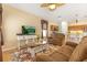 Open-concept living room with wood floors, comfortable seating, and an adjacent kitchen at 477 Orange Cosmos Blvd, Davenport, FL 33837