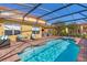The screened-in pool and hot tub features a brick patio with lounge furniture and open backyard at 477 Orange Cosmos Blvd, Davenport, FL 33837