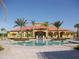 Enjoy the large community pool with a stunning clubhouse backdrop surrounded by palm trees at 477 Orange Cosmos Blvd, Davenport, FL 33837