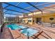 The backyard features a screened-in pool and hot tub with brick patio and lounge furniture at 477 Orange Cosmos Blvd, Davenport, FL 33837
