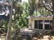 Backyard deck and exterior of home with lush garden featuring plants and trees draped with Spanish moss at 5019 Pineapple St, Lake Wales, FL 33898