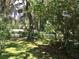 Tranquil backyard with lush greenery, moss-draped trees, and a glimpse of the fenced perimeter at 5019 Pineapple St, Lake Wales, FL 33898