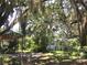 View of the home and surrounding landscape, featuring lush trees and Spanish moss at 5019 Pineapple St, Lake Wales, FL 33898
