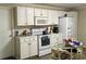 Kitchen with white cabinets, appliances, and a breakfast table at 5019 Pineapple St, Lake Wales, FL 33898