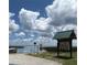 Scenic lake view with a clear blue sky and cumulus clouds, next to an information board at 5019 Pineapple St, Lake Wales, FL 33898