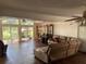 Spacious living room featuring wood floors, a ceiling fan, and large windows overlooking the outdoors at 5019 Pineapple St, Lake Wales, FL 33898