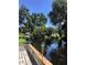 Picturesque waterfront view of the calm water from a wooden deck with trees and lush landscaping at 5019 Pineapple St, Lake Wales, FL 33898