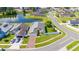 Aerial view of home with green lawn, grey roof, pond, and convenient street access at 5100 Violet Ln, Kissimmee, FL 34758