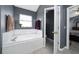 Well-lit bathroom featuring a soaking tub and an open doorway to the bedroom at 5100 Violet Ln, Kissimmee, FL 34758