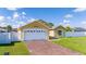 Yellow home with two-car garage, well maintained lawn, and white picket fence at 5100 Violet Ln, Kissimmee, FL 34758