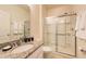 Well-lit bathroom boasts a granite countertop, sleek fixtures, and a glass-enclosed shower for a modern touch at 5231 Wildwood Way, Davenport, FL 33837