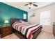 A relaxing bedroom features a dark wooden bed frame, striped bedding, and a bedside table with lamp at 5231 Wildwood Way, Davenport, FL 33837