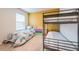 Bedroom featuring a bunk bed, twin bed, colorful wall, and natural lighting at 5231 Wildwood Way, Davenport, FL 33837