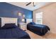 Bright bedroom with two twin beds, blue accent wall and a window at 5231 Wildwood Way, Davenport, FL 33837