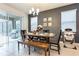 Dining area with a wooden table and chairs, a modern chandelier, and sliding glass doors at 5231 Wildwood Way, Davenport, FL 33837