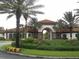 Attractive entrance to the community center, beautifully landscaped with flowers and lush greenery at 5231 Wildwood Way, Davenport, FL 33837