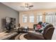 Comfortable living room with a leather reclining sofa, large windows, and a modern ceiling fan at 5231 Wildwood Way, Davenport, FL 33837