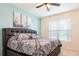Calming main bedroom featuring a plush bed, a ceiling fan, and natural light from the window at 5231 Wildwood Way, Davenport, FL 33837