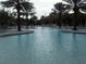 Stunning community pool with well-manicured landscaping and palm trees at 5231 Wildwood Way, Davenport, FL 33837