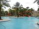 Resort-style pool featuring a waterslide and lush tropical landscaping, perfect for relaxation and recreation at 5231 Wildwood Way, Davenport, FL 33837