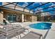 Screened-in pool with lounge chairs and partial covered patio at 5231 Wildwood Way, Davenport, FL 33837