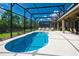 Private screened-in pool surrounded by lush landscaping and outdoor dining area at 5231 Wildwood Way, Davenport, FL 33837