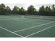 A pair of tennis courts featuring nets, surrounded by green landscaping, ready for a game of tennis at 5231 Wildwood Way, Davenport, FL 33837
