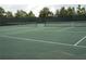 A pair of tennis courts featuring nets, surrounded by green landscaping, ready for a game of tennis at 5231 Wildwood Way, Davenport, FL 33837