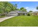 Inviting home showcasing lush green lawn, mature trees, and solar panels for energy efficiency at 878 Elgin Dr, Winter Springs, FL 32708