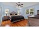 Serene primary bedroom features hardwood floors, two windows, and a ceiling fan at 878 Elgin Dr, Winter Springs, FL 32708