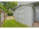 Backyard storage shed matching the exterior of the home with lawn at 878 Elgin Dr, Winter Springs, FL 32708